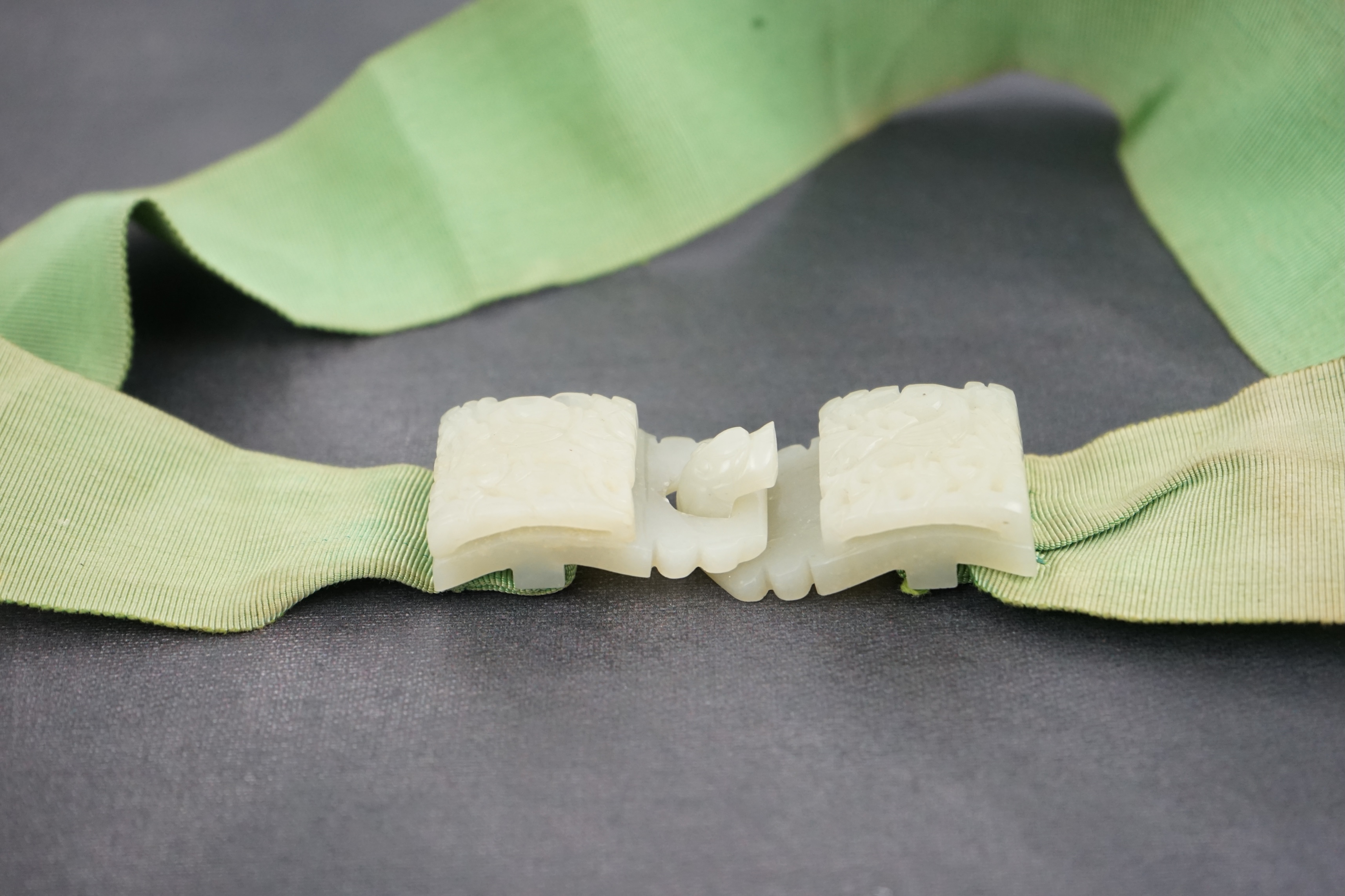 A Chinese pale celadon jade two-piece reticulated belt buckle, 19th century